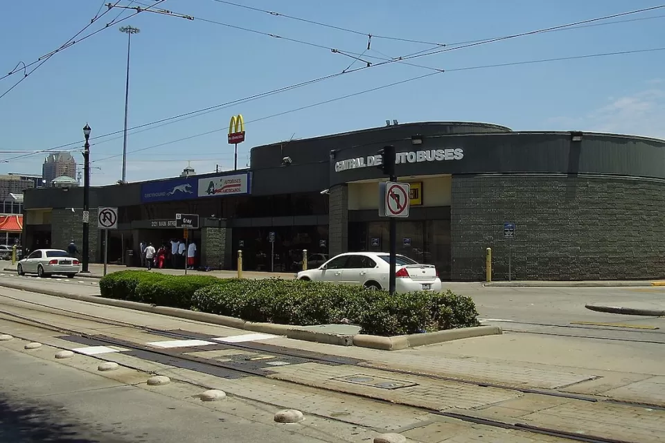 Greyhound bus station in Houston, Texas next to street with light rail tracks.